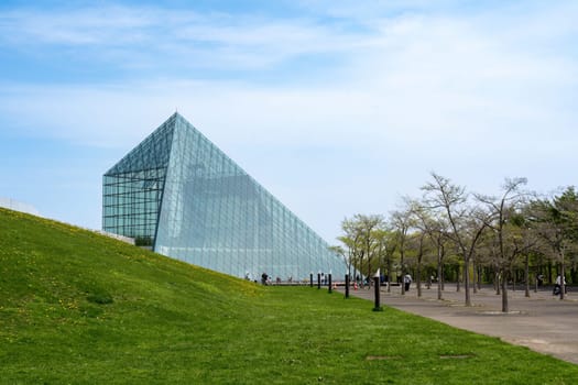 SAPPORO, JAPAN - 05 MAY 2024 : The symbol of Moerenuma park, the glass pyramid Hidamari, on February 5 in Sapporo. The glass pyramid is multi-purpose space, such as cultural activities and museum.