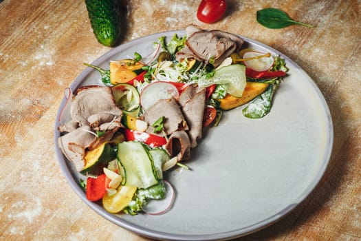 A colorful assortment of fresh vegetables and savory meats arranged on a natural wooden table, showcasing a healthy and delicious meal.