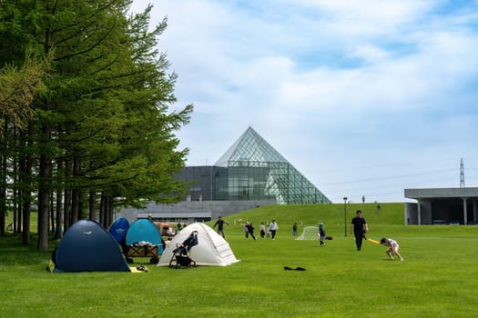 SAPPORO, JAPAN - 05 MAY 2024 : The symbol of Moerenuma park, the glass pyramid Hidamari, on February 5 in Sapporo. The glass pyramid is multi-purpose space, such as cultural activities and museum.