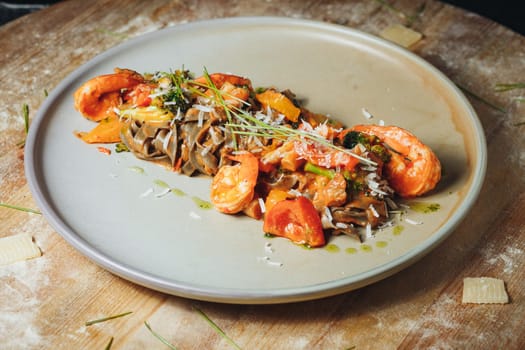 A delicious plate of pasta topped with succulent shrimp and fresh tomatoes, ready to be savored.