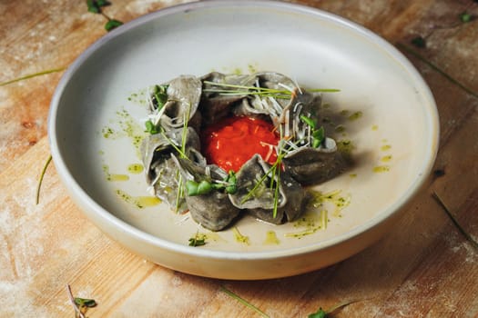 A bowl filled with steaming dumplings rests on a weathered wooden table in a cozy setting.