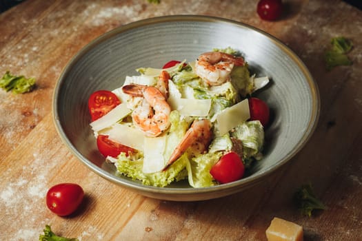 A delectable bowl brimming with fresh shrimp, juicy tomatoes, and savory cheese, creating a colorful and flavorful salad.