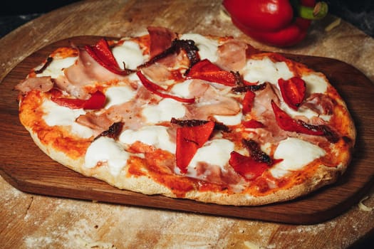 A fresh, piping hot pizza is displayed on a rustic wooden cutting board, showcasing its gooey cheese, savory toppings, and crispy crust.