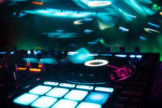 professional DJ mixer controller for mixing music in a nightclub with color effects