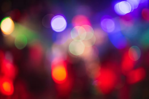 multicolored bokeh from bright colored spotlights in a nightclub in out of focus