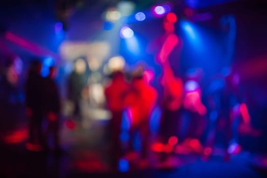 blurred abstract background with colorful bokeh from bright spotlights in a nightclub