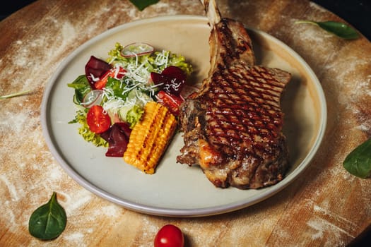 A plate with a succulent steak cooked to perfection and a fresh salad with vibrant greens and colorful vegetables.