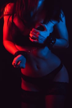fitness body of a young girl with sexy attractive forms of Breasts and ass in underwear and stockings with handcuffed hands. BDSM concept of sex with submission and domination, role-playing games