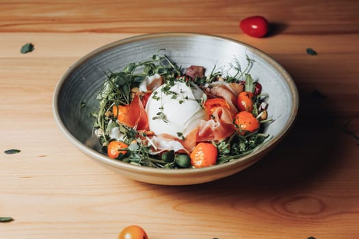 A fresh salad bowl filled with succulent ham slices, vibrant tomatoes, and crisp greens, creating a colorful and tasty meal.