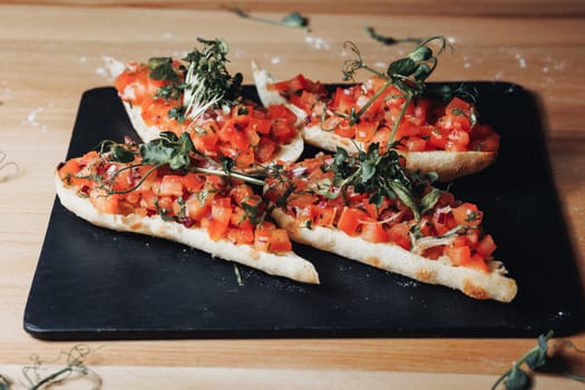 A plate brimming with freshly made bruschetta topped with juicy tomatoes and fragrant herbs, enticing the viewer with its vibrant colors and savory aroma.