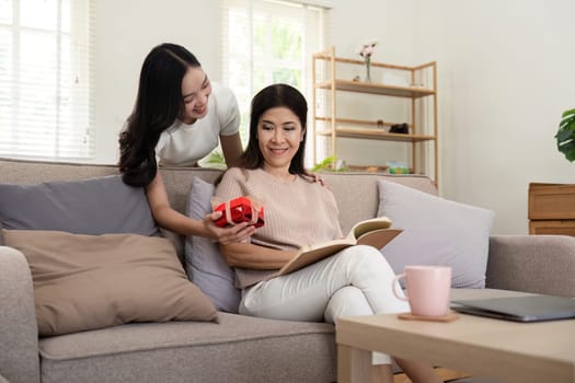 Happy mother's day Beautiful young woman and her mother with gift box at home.