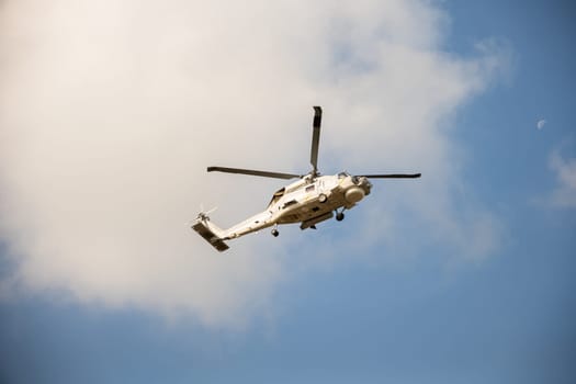 Modern helicopter in flight against blue sky. New engine technology for rescue and transport. Pilot maneuvers small aircraft with speed and precision showcasing hovering capability.