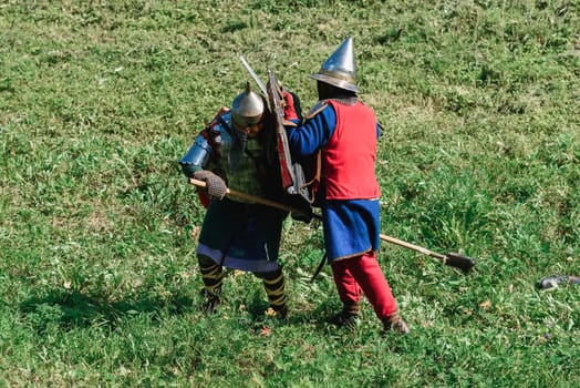 LUH, RUSSIA - AUGUST 27, 2016: Reconstruction of medieval battle of knights in armor and weapons at the festival of Onions in the village of Luh