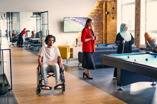 An African-American young entrepreneur in a wheelchair is surrounded by his business colleagues in a modern office setting, embodying diversity and collaboration in the workplace.