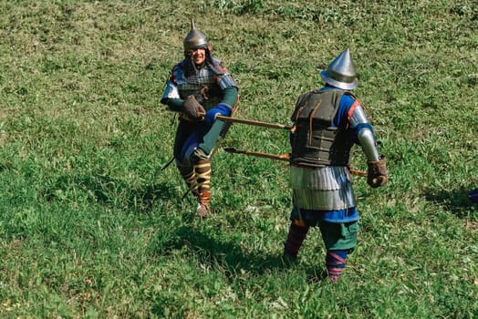 LUH, RUSSIA - AUGUST 27, 2016: Reconstruction of medieval battle of knights in armor and weapons at the festival of Onions in the village of Luh