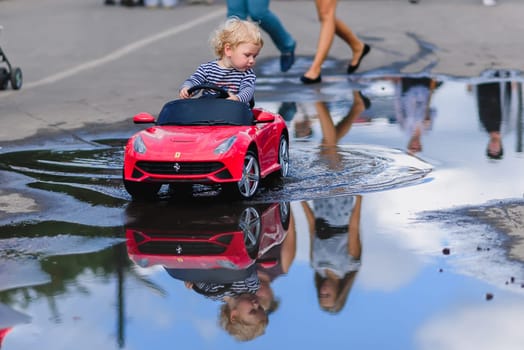 LUH, RUSSIA - AUGUST 27, 2016: little boy child rides an electric mini car