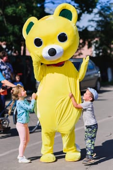 LUH, RUSSIA - AUGUST 27, 2016: little boy and a girl play with a large growth doll at a festive festival
