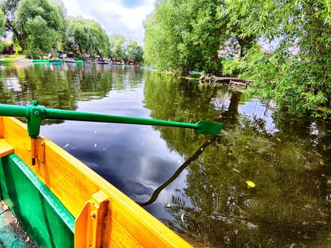 The paddle of a boat and the water of a large lake in the background. Natural landscape, travel, recreation. boat paddle extends over a calm lake