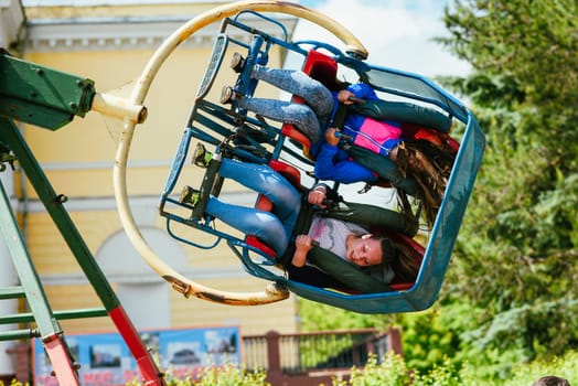 VICHUGA, RUSSIA - JUNE 24, 2017: Two girls ride a carousel in the Park on the Day of Vichuga, Russia