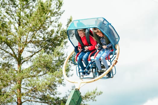 VICHUGA, RUSSIA - JUNE 24, 2017: Two girls ride a carousel in the Park on the Day of Vichuga, Russia