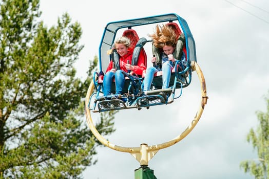 VICHUGA, RUSSIA - JUNE 24, 2017: Two girls ride a carousel in the Park on the Day of Vichuga, Russia