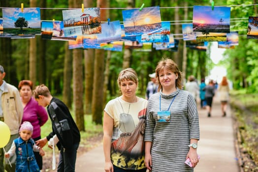VICHUGA, RUSSIA - JUNE 24, 2017: Two women at a photo exhibition in the Park on the day of Vichuga, Russia