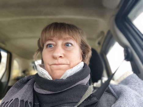 Funny Middle aged woman in car taking selfie while enjoying a drive. Female mature driver posing inside car. Funny happy tourist girl in alone travel