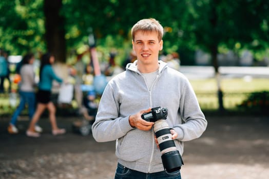VICHUGA, RUSSIA - JUNE 24, 2017: Photographer with a professional camera and smiling at the celebration of the city of Vichuga, Russia