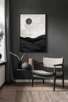 A black and white painting of a mountain landscape with a sun in the sky. The painting is framed and hangs on a wall. A chair is placed in front of the painting
