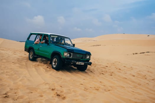 MUI NE, VIETNAM - MARCH 6, 2017: Tourists ride in a jeep in the White Sand Dunes Muine in Vietnam in the summer