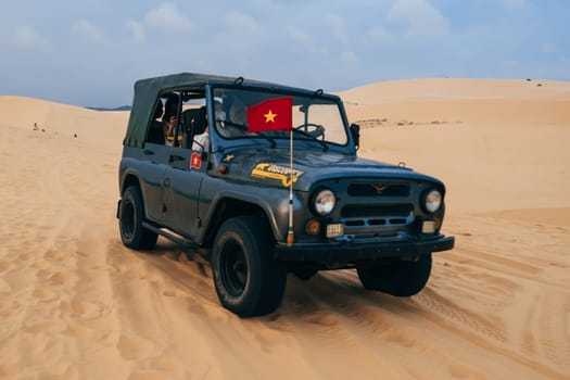 MUI NE, VIETNAM - MARCH 6, 2017: Tourists ride in a jeep in the White Sand Dunes Muine in Vietnam in the summer