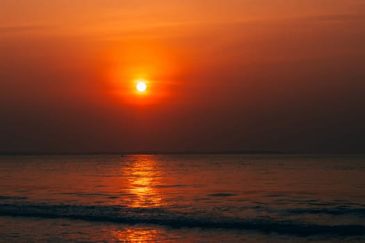 red sunrise at sea with waves in summer