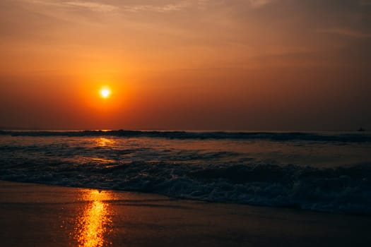 waves at sea against the orange sunrise in summer