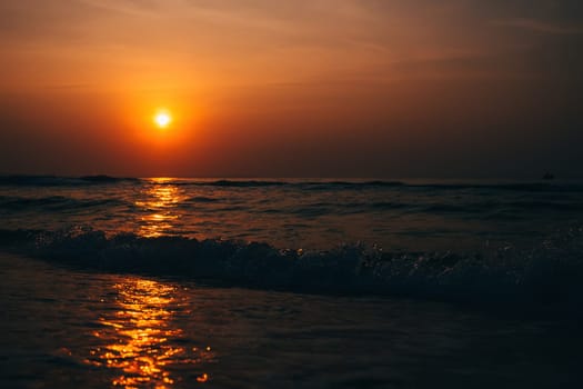 waves at sea against the orange sunset in summer