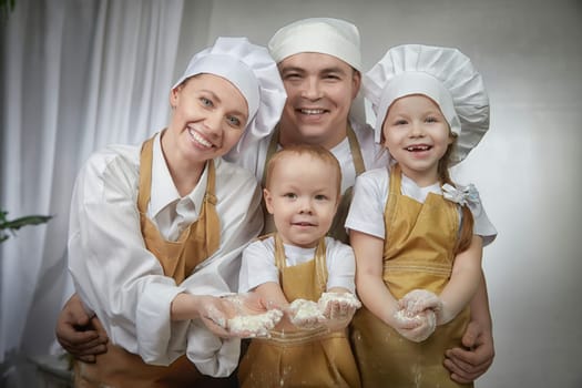 Cute oriental family with mother, father, daughter, son cooking in kitchen on Ramadan, Kurban-Bairam. Funny family at photo shoot. Easter