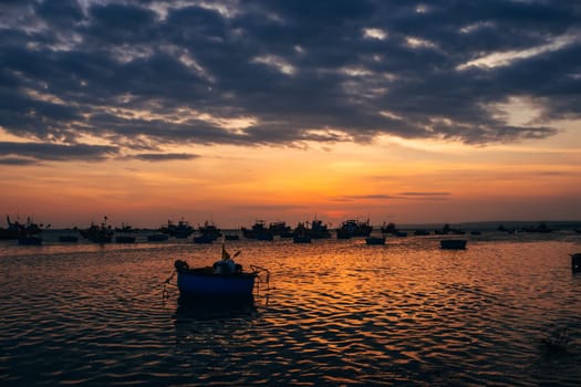 silhouettes of boats for fishing on the sea in Vietnam at sunset
