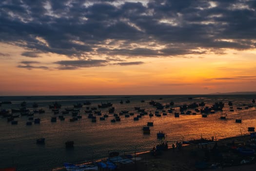 silhouettes of boats for fishing on the sea in Vietnam at sunset