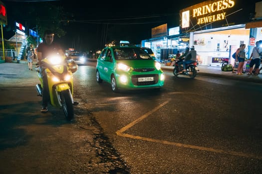 MUI NE, VIETNAM - CIRCA MARCH 2017: Traffic on the street at night on the background of shops