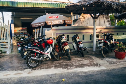 MUI NE, VIETNAM - CIRCA MARCH 2017: A lot of motorbikes standing on the sidewalk