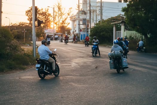 MUI NE, VIETNAM - CIRCA MARCH 2017: A lot of people riding motorbikes on the road