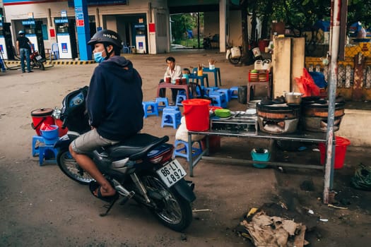 MUI NE, VIETNAM - CIRCA MARCH 2017: Vietnamese near gas station on the sidewalk