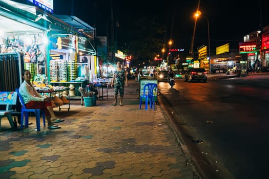MUI NE, VIETNAM - CIRCA MARCH 2017: Night life on a busy street against the backdrop of many shops