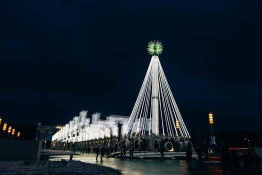 MOSCOW, RUSSIA - DECEMBER 25, 2016: Artificial Christmas fir illuminated at ENEA with visitors to Moscow. Russia