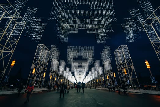 MOSCOW, RUSSIA - DECEMBER 25, 2016: The main alley of VDNKH decorated with Christmas lights the night before the New Year, Moscow. Russia