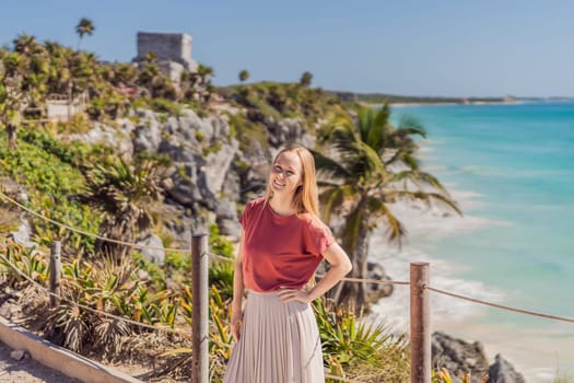 Woman tourist enjoying the view Pre-Columbian Mayan walled city of Tulum, Quintana Roo, Mexico, North America, Tulum, Mexico. El Castillo - castle the Mayan city of Tulum main temple.