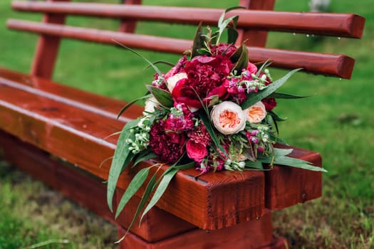 beautiful wedding bouquet with red peonies and green leaves