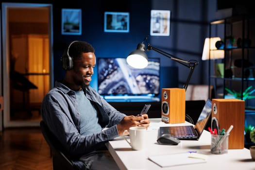 African american guy messaging on smartphone app, attending online seminar course in living room. Young person learning about finances and accounting for business administration training program.