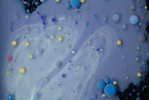 A myriad of oil droplets intermingling with water, creating a mesmerizing effect reminiscent of a galaxy.