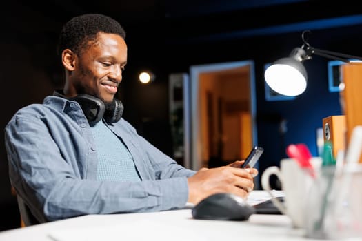 Male student sending sms online on mobile phone, attending professional training course on internet network. Young adult browsing social media sites and joining web training class program.