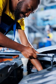 Engineer expertly examines car exhaust pipes using advanced mechanical tools, ensuring optimal automotive performance and safety. Garage employee conducts annual vehicle checkup, close up